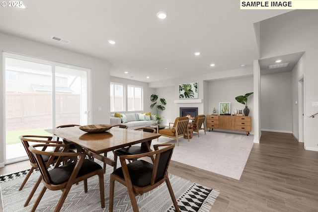 8836 SW Peia Ln, Tualatin, OR 97062 - dining space with a glass covered fireplace, recessed lighting, light wood-style floors, and baseboards