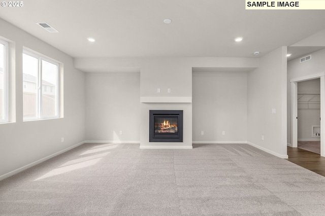 8836 SW Peia Ln, Tualatin, OR 97062 - unfurnished living room featuring carpet, a glass covered fireplace, baseboards, and recessed lighting