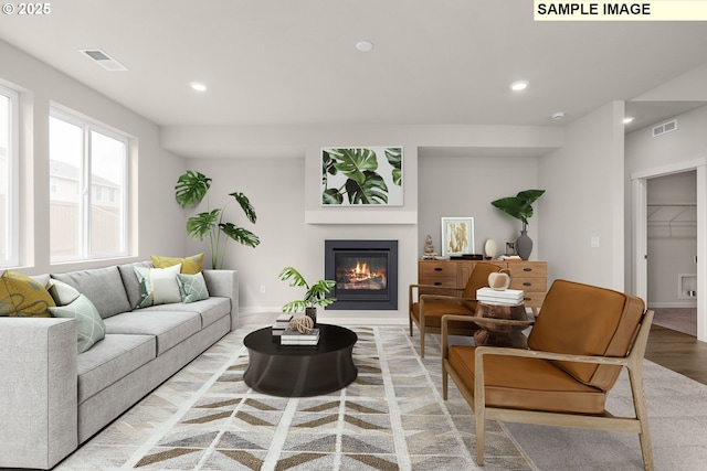 8836 SW Peia Ln, Tualatin, OR 97062 - living room featuring a glass covered fireplace, recessed lighting, light wood-style floors, and baseboards