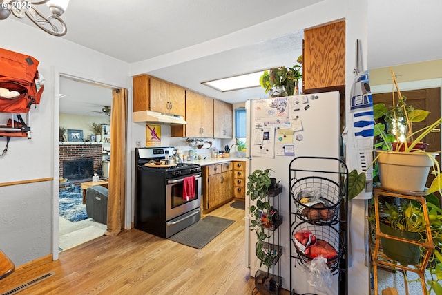 1842 NW Dogwood St, Roseburg, OR 97471 - kitchen featuring stainless steel range with gas stovetop, freestanding refrigerator, under cabinet range hood, light wood-style floors, and light countertops