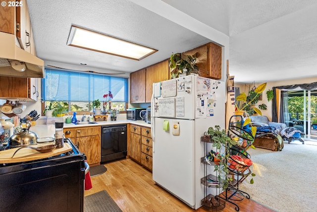 1842 NW Dogwood St, Roseburg, OR 97471 - kitchen featuring black appliances, under cabinet range hood, brown cabinetry, a sink, and light wood finished floors