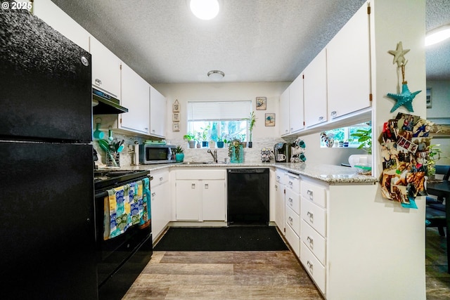 kitchen featuring sink, a textured ceiling, black appliances, and white cabinets