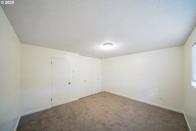 unfurnished bedroom with a closet, carpet, and a textured ceiling