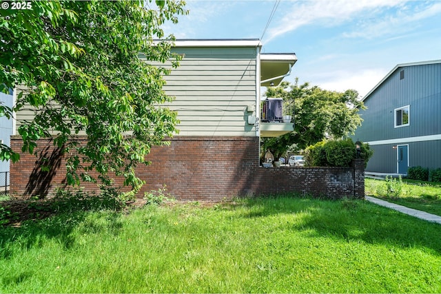 view of property exterior featuring a balcony and a yard