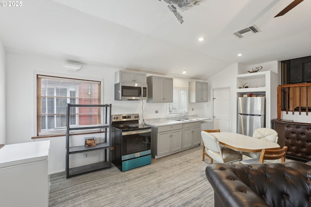 kitchen with stainless steel appliances, gray cabinetry, visible vents, and a sink
