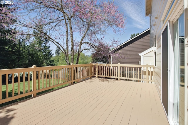 wooden terrace featuring a lawn