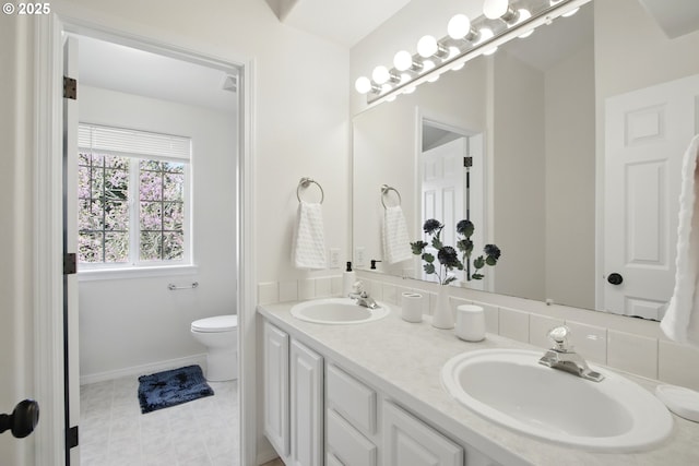 full bathroom with toilet, double vanity, baseboards, and tile patterned floors