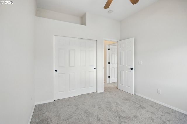 unfurnished bedroom with carpet floors, baseboards, a closet, and a ceiling fan