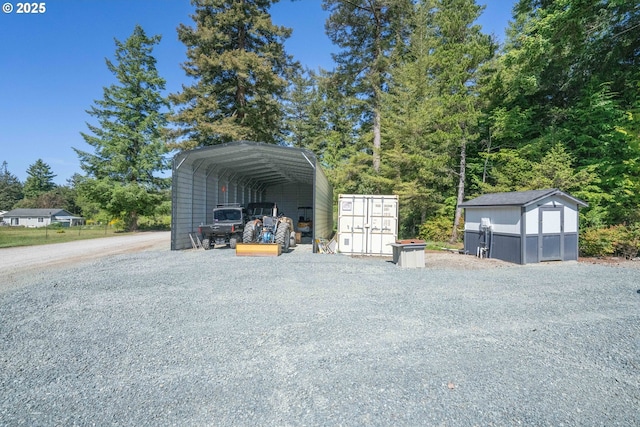 87477 Jean Dr, Bandon, OR 97411 - garage featuring a carport, a shed, and gravel driveway