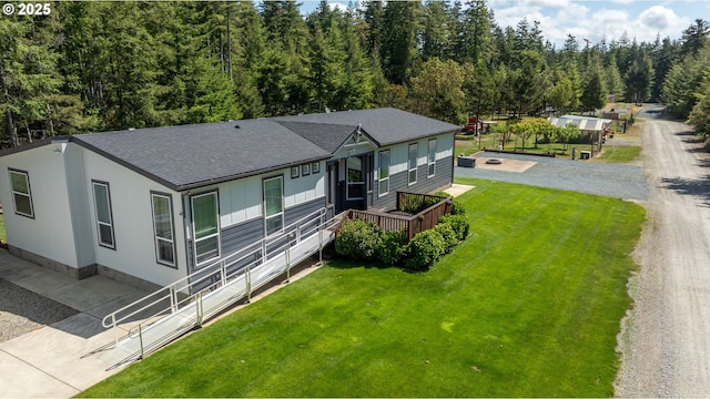 87477 Jean Dr, Bandon, OR 97411 - view of front of house with a shingled roof, gravel driveway, a front yard, and a wooden deck