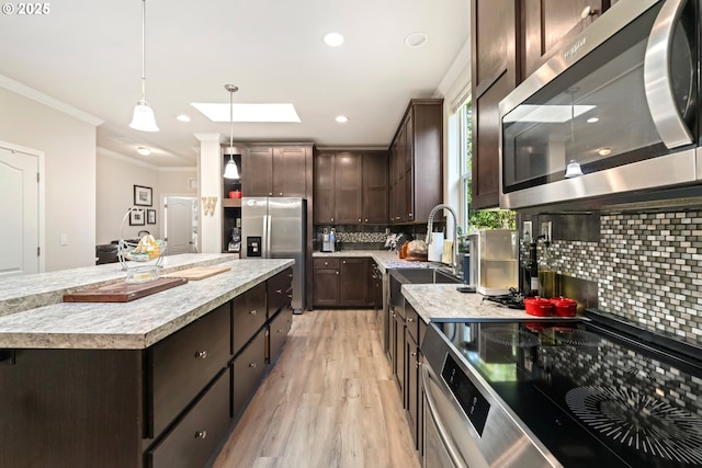 87477 Jean Dr, Bandon, OR 97411 - kitchen featuring appliances with stainless steel finishes, crown molding, a sink, dark brown cabinets, and backsplash