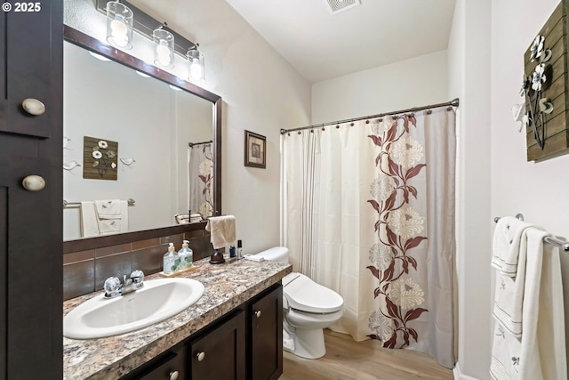 87477 Jean Dr, Bandon, OR 97411 - full bath with wood finished floors, toilet, vanity, and a shower with shower curtain