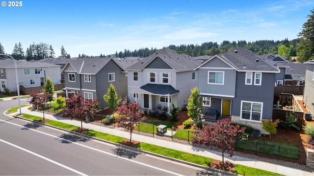 11649 SE Pleasant Valley Pkwy, Happy Valley, OR 97086 - view of front of home with a residential view, a fenced front yard, and stone siding
