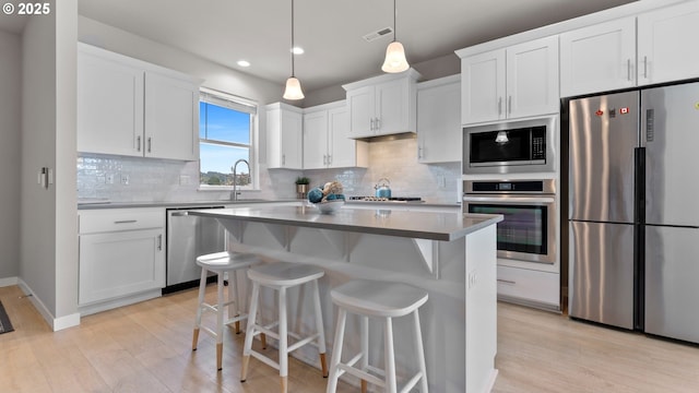 11649 SE Pleasant Valley Pkwy, Happy Valley, OR 97086 - kitchen with appliances with stainless steel finishes, light wood-type flooring, white cabinets, and recessed lighting
