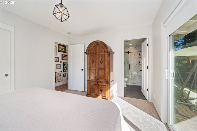 bedroom featuring a barn door, baseboards, and ensuite bathroom