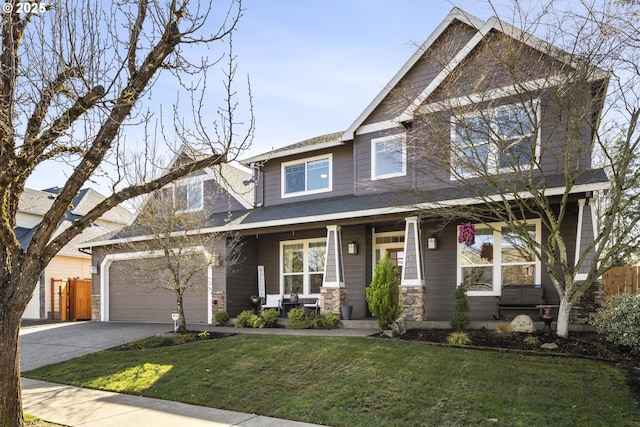 craftsman house featuring a porch, fence, a front lawn, and driveway