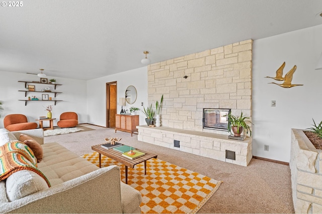 living room featuring baseboards, a textured ceiling, a stone fireplace, and carpet flooring