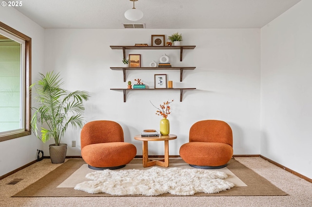 living area featuring baseboards, visible vents, and carpet floors