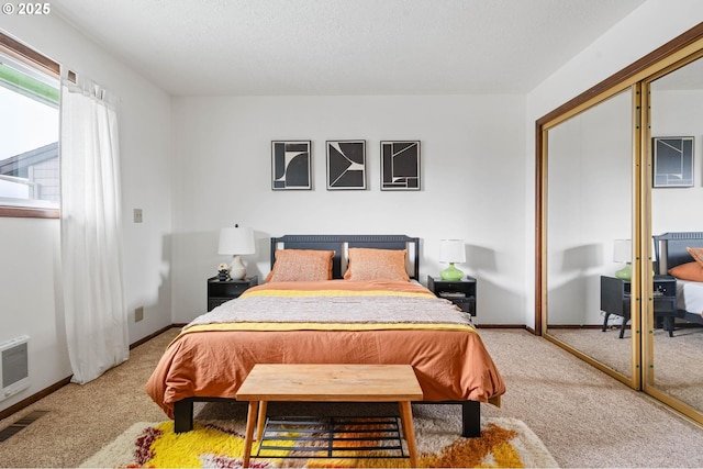 bedroom with a closet, visible vents, light colored carpet, and baseboards