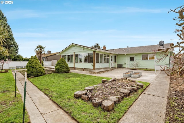 back of house featuring fence, central AC, a chimney, a yard, and a patio area