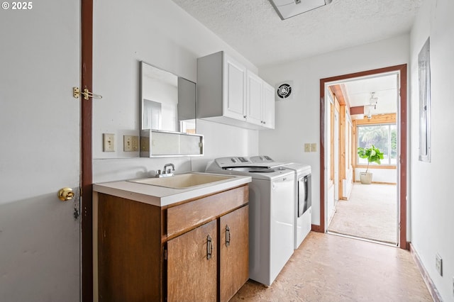 washroom with visible vents, independent washer and dryer, a sink, a textured ceiling, and cabinet space