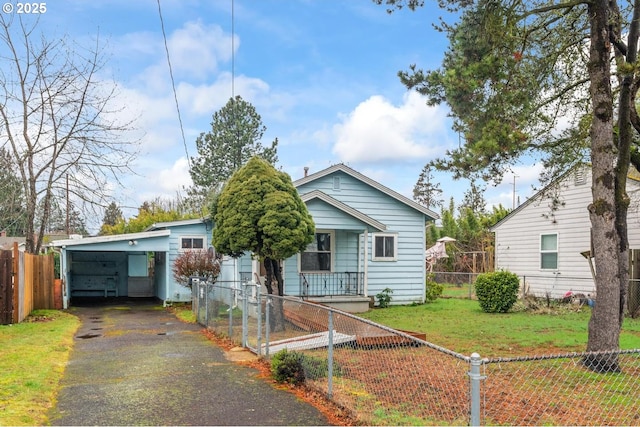 bungalow featuring aphalt driveway, a fenced front yard, a front lawn, and a carport