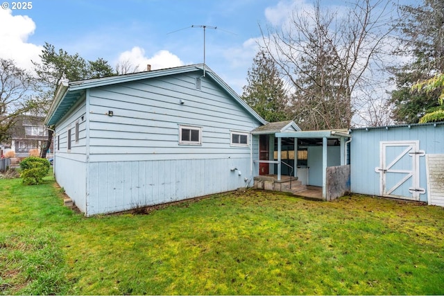 rear view of property featuring a shed, an outdoor structure, and a yard