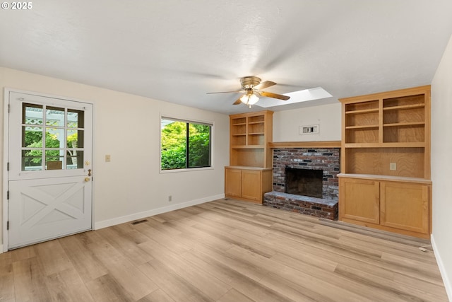 420 Mar Loop, Eugene, OR 97401 - unfurnished living room with a ceiling fan, a brick fireplace, light wood-style flooring, and baseboards