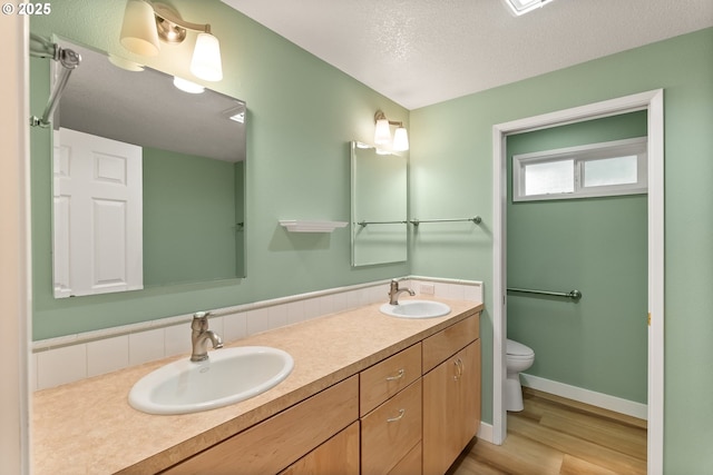420 Mar Loop, Eugene, OR 97401 - full bath with toilet, double vanity, wood finished floors, baseboards, and a textured ceiling