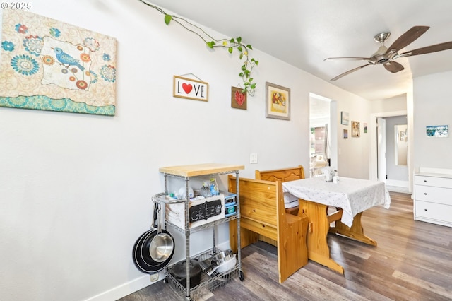 dining room with baseboards, ceiling fan, and wood finished floors