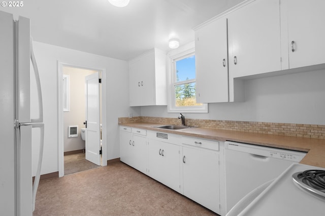 kitchen featuring tasteful backsplash, sink, white cabinets, and white appliances