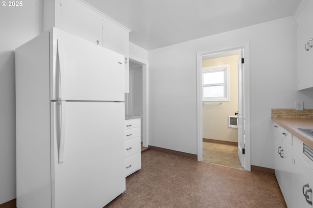 kitchen with decorative backsplash, white fridge, and white cabinets