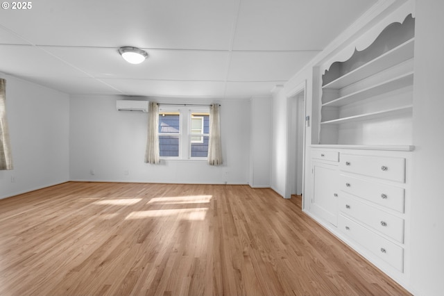 unfurnished room with light hardwood / wood-style floors and a wall mounted AC