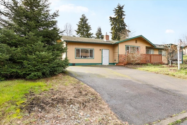 single story home featuring driveway and a chimney