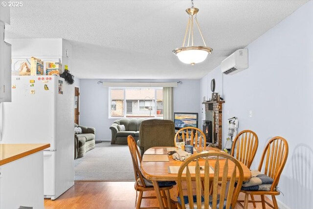744 NE Craig St, Myrtle Creek, OR 97457 - dining area with a wall mounted AC, light wood-style floors, and a textured ceiling