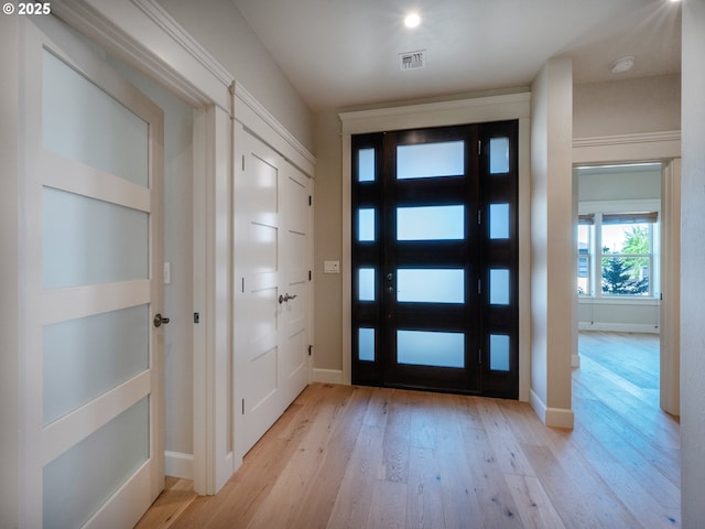 foyer entrance featuring light wood-style flooring and baseboards