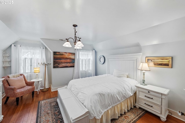 bedroom featuring baseboards, hardwood / wood-style floors, and vaulted ceiling