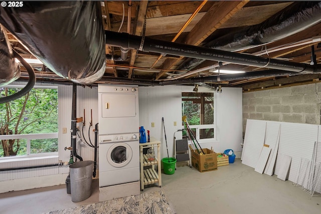 below grade area with stacked washer and clothes dryer and concrete block wall