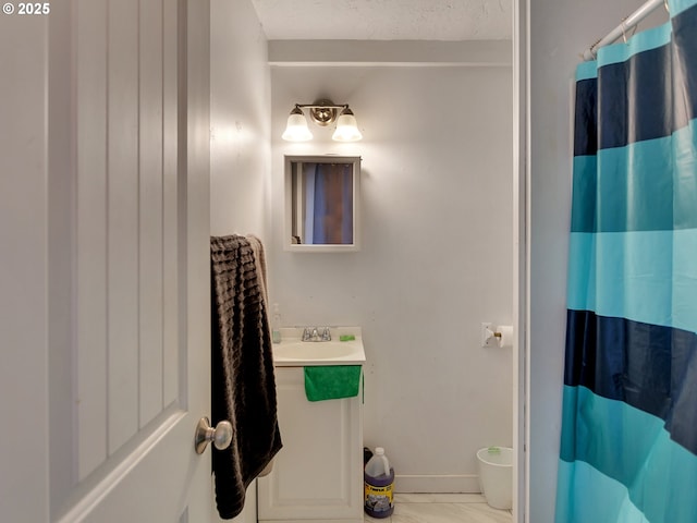 bathroom featuring curtained shower, sink, and a textured ceiling