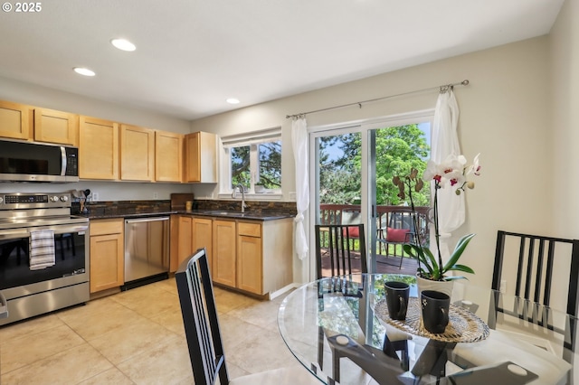 kitchen with stainless steel appliances, light brown cabinets, a sink, recessed lighting, and light tile patterned floors