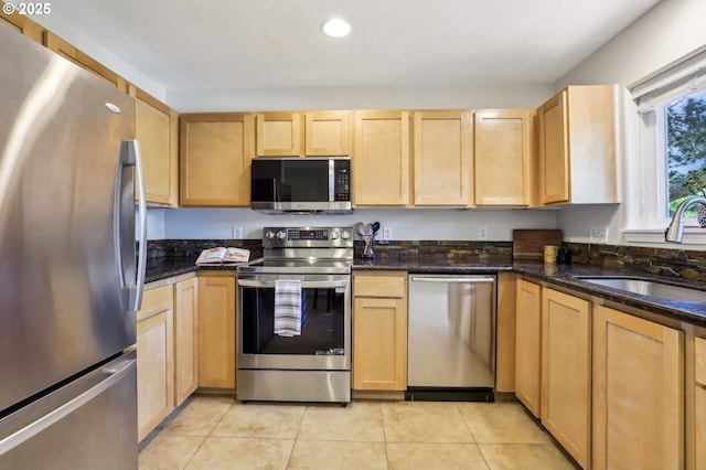 kitchen featuring stainless steel appliances, a sink, light brown cabinetry, light tile patterned floors, and recessed lighting