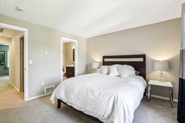 carpeted bedroom with baseboards and connected bathroom