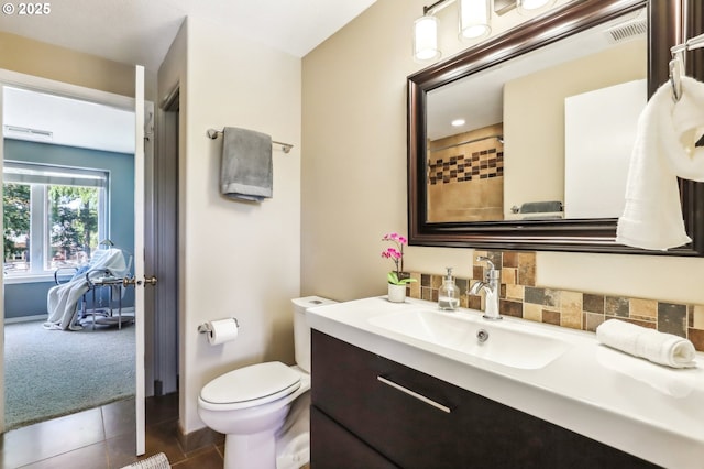 bathroom with toilet, vanity, and tile patterned flooring