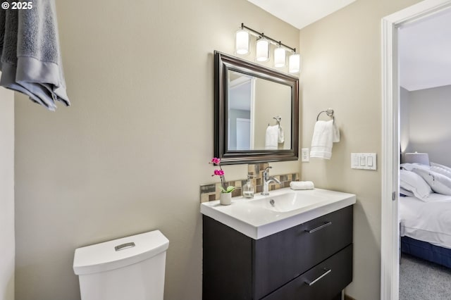 ensuite bathroom featuring vanity and toilet