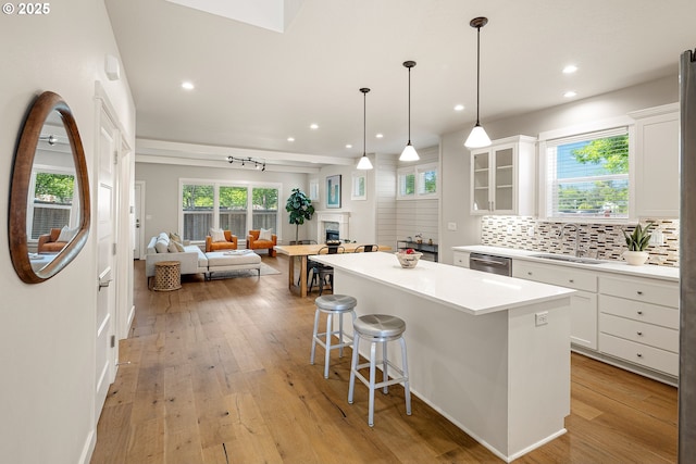 1408 Taylor St, Eugene, OR 97402 - kitchen featuring dishwasher, a kitchen island, a kitchen bar, white cabinets, and backsplash
