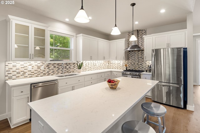 1408 Taylor St, Eugene, OR 97402 - kitchen featuring stainless steel appliances, wall chimney exhaust hood, a sink, white cabinets, and light wood-type flooring