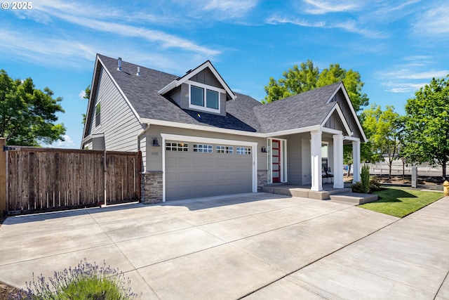 1408 Taylor St, Eugene, OR 97402 - view of front facade with covered porch, driveway, stone siding, roof with shingles, and an attached garage