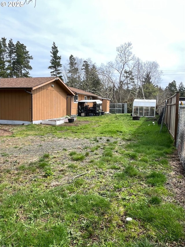 view of yard with an outdoor structure and fence