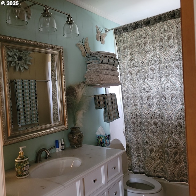 bathroom featuring toilet, vanity, and ornamental molding