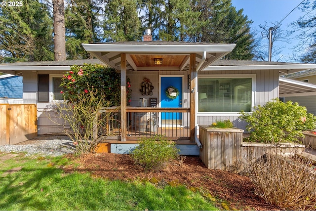 doorway to property featuring a porch and a chimney